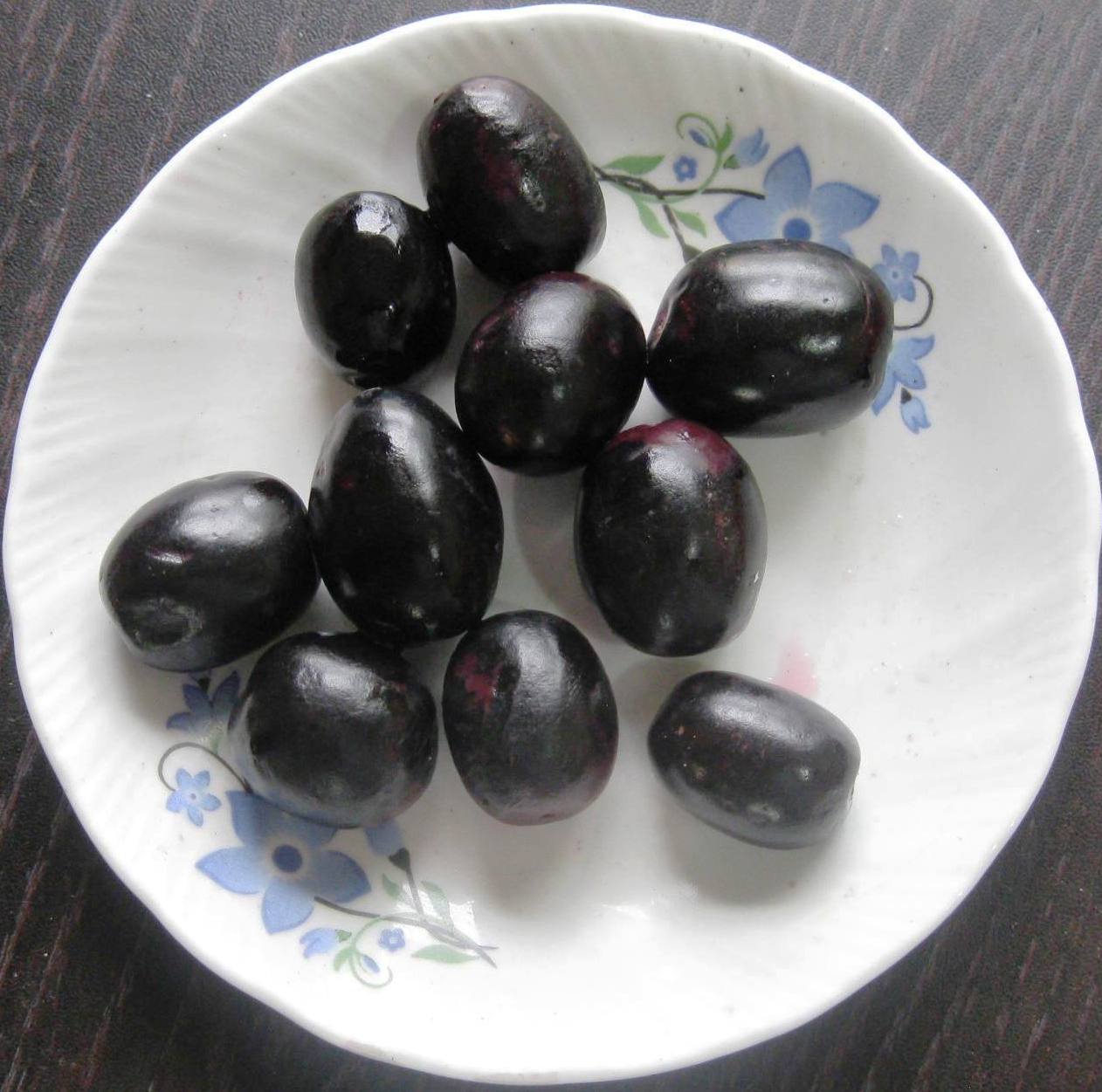 Ripe Java plums arranged on a white plate